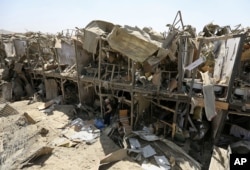 FILE - A security guard stands amid the damage of a truck bombing, in Kabul, Afghanistan, Monday, Aug. 1, 2016.