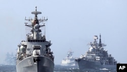 In this May 24, 2014 photo, China's Harbin (112) guided missile destroyer, left, and the DDG-139 Ningbo Sovremenny class Type-956EM destroyer, right, take part in a China-Russia "Joint Sea-2014" navy exercise at the East China Sea off Shanghai, China.
