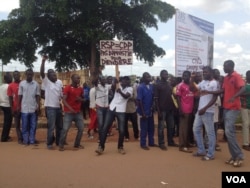 Protesters gather along the road where the ECOWAS delegation traveled in Ouagadougou, Burkina Faso, Sept. 24, 2015. The sign's message in French "No amnesty for Diendéré." (VOA / E. Iob)