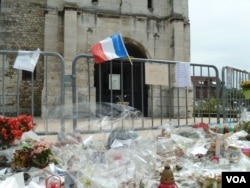 Offerings are left outside St. Therese Catholic Church, where Father Jacques Hamel was killed while celebrating Mass in July. (L. Ramirez/VOA)