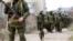Armed men, believed to be Russian servicemen, walk outside a Ukrainian military base in Perevalnoye, near the Crimean city of Simferopol, March 14, 2014.