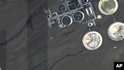 This image provided by NOAA taken Aug. 31, 2021, and reviewed by The Associated Press shows oil slicks at the flooded Phillips 66 Alliance Refinery in Belle Chasse, La.