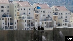 Anggota pasukan keamanan Israel menembakkan gas air mata di desa Bilin, dekat kota Ramallah, Tepi Barat. (Foto: AFP)