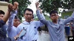 FILE - Image made from video released by the Democratic Voice of Burma, July 18, 2017, shows (L-R) Burmese journalists Lawi Weng, from the Irrawaddy, Aye Nai, from the Democratic Voice of Burma, and Pyae Bone Naing, from the Democratic Voice of Burma, raising chained wrists decrying lack of freedom and democracy, Shan state, Myanmar. 