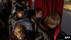 Los niños viajan en un autobús durante su evacuación en el oeste de Ucrania, desde la ciudad sureña de Jersón, el 30 de octubre de 2023, en medio de la invasión rusa de Ucrania.