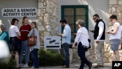 In this Friday, Feb. 28, 2020 photo, voters wait in line at an early polling site in San Antonio. California and Texas are the most populous states in the nation and the biggest delegate prizes for the candidates, yet they also present a stark…