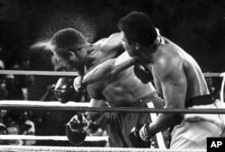 FILE - George Foreman takes a right to the head from challenger Muhammad Ali in the seventh round of the match dubbed the Rumble in the Jungle in Kinshasa, D.R.C., Oct. 30, 1974.