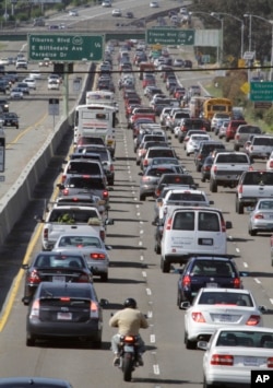 FILE - A motorcyclist rides between lanes as traffic backs up on U.S. Highway 101 in Mill Valley, Calif., May 26, 2011. California, 16 other states and the District of Columbia sued the Trump administration on May 1, 2018, over its plans to scrap standards on vehicle greenhouse gas emissions, which help set gas mileage rules.