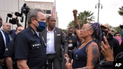 Los Angeles Police Department Chief Michel Moore speaks to a protester after a vigil with members of professional associations and the interfaith community at LAPD headquarters, June 5, 2020, in Los Angeles. 