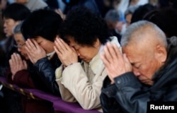 FILE - Believers take part in a weekend mass at an underground Catholic church in Tianjin.