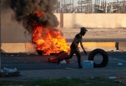 Anti-government protesters set fires and close a street during a demonstration in Baghdad, Iraq, Oct. 4, 2019.
