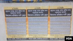 ভেঙে ফেলা ভাস্কর্যের পেছনে নিষিদ্ধ সংগঠন হিযবুত তাহরীরের কয়েকটি পোস্টার লাগানো ছিল।