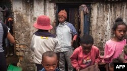FILE - Residents of Anjezika, one of Antananarivo's poorest and most unhealthy neighborhoods, stand around on May 13, 2020. 