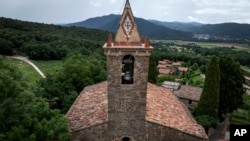 View of the bell tower of the12th-century Sant Romà church, where students of the Vall d'en Bas School of Bell Ringers perform playing bells, at the tiny village of Joanetes, about two hours north of Barcelona, Spain, June 29, 2024.