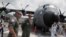 FILE - Members of the flight crew stand in front of the U.S. Air Force Reserve's "Hurricane Hunter" WC-130J aircraft at Panama Pacifico Airport, at an exhibition during its Caribbean Hurricane Awareness Tour, in Panama City, Panama, April 26, 2018. 