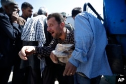 A Syrian man holds bread as Syrian authorities distributed basic staples to Douma residents, near Damascus, Syria, April 16, 2018.