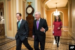Senate Majority Leader Mitch McConnell, center, walks with Sen. Pat Toomey to the chamber for the vote to impose more stringent sanctions on North Korea, Feb 10, 2016.
