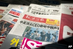 A newspaper with front-page coverage of Chinese President Xi Jinping's trip to the United States sits for sale at a newsstand in Beijing, Sept. 25, 2015.