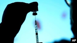 FILE - A dose of a Pfizer COVID-19 vaccine is prepared on Nov. 5, 2021, in Chicago.Three new studies offer more evidence that the COVID-19 vaccines are standing up to the omicron variant, at least among people who have received booster shots.
