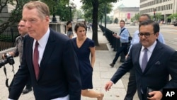 Kepala USTR Robert Lighthizer (kiri) dan Menteri Economi Meksiko, Idelfonso Guajardo berjalan ke Gedung Putih hari Senin (27/8). AS dan Meksiko menyetujui perjanjian perdagangan baru pengganti NAFTA. 