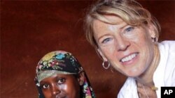 Carolyn Miles sits with Isnino Adan and her two-month old baby girl, Habibo. Isnino, 16 years old, gave birth two months ago in a truck during her journey from Somalia to the Dadaab refugee camp in Kenya. Save the Children placed Isnino with a foster fami