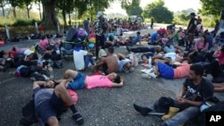 FILE - Migrants who are part of a caravan heading toward Mexico's northern border and ultimately the U.S., rest in southern Mexico, Nov. 7, 2024. Mexican immigration authorities have broken up two small migrant caravans headed to the U.S. border, activists said on Saturday. 
