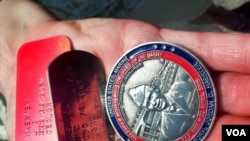 “Gold Star” Mother JoAnne Lyles holds her late son’s dog tags and a commemorative medallion struck in his honor. (A. Phillips/VOA)