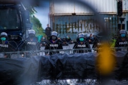 Police officers stand guard of Thailand's government buildings as barbed wire separates anti-government protesters, Bangkok, Thailand, July 2021.