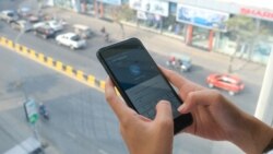 ស្ត្រីម្នាក់ប្រើទូរស័ព្ទស្មាតហ្វូនដើម្បីប្រើសេវាធនាគារ ABA នៅរាជធានីភ្នំពេញ កាលពីថ្ងៃទី២ ខែមីនា ឆ្នាំ២០២១។ (ទុំ ម្លិះ/វីអូអេ)