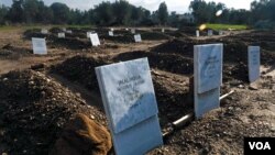 From left, refugees' tombs display childrens' names and ages in Arabic and English, “Jalal Molla, 4 years old” and “Ala Hajo, 6 years old,” Jan. 23, 2016. (H. Elrasam/VOA)