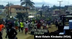 Hundreds of youths run through the streets of Ekona, cheering, waving palm fronds, and holding signs demanding independence in this image taken from video, Sept. 22, 2017.