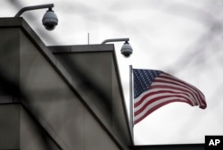 American flag waves beside CCTV cameras on top of the U.S. embassy in Berlin, Germany, Oct. 25, 2013.
