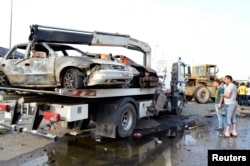 Four car bomb attacks and a mortar strike around Shi'ite parts of northern Baghdad killed 36 people and wounded 98 within a span of two hours Thursday, police and medical officials said. People gather at the site of a car bomb attack in Baghdad, Oct. 16,