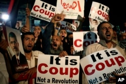 Supporters of Egypt's ousted President Mohammed Morsi chant slogans against Egyptian Defense Minister Gen. Abdel-Fattah el-Sissi at Nasr City, July 28, 2013.