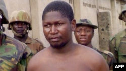 FILE - Handout photo obtained on August 5, 2009 shows Mohammed Yusuf surrounded by soldiers at Giwa Barracks in Maiduguri, northeastern Nigeria, on July 30, 2009 shortly after his capture by Nigerian troops.