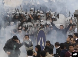 FILE - Egyptian anti-government activists clash with riot police in Cairo, Egypt, Jan. 28, 2011.