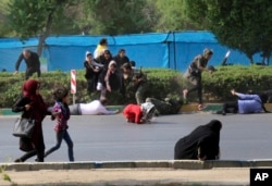 In this photo provided by Mehr News Agency, civilians try to take cover in a shooting attack during a military parade marking the 38th anniversary of Iraq's 1980 invasion of Iran, in the southwestern city of Ahvaz, Iran, Sept. 22, 2018.