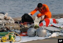 A member of Indonesian Search and Rescue Agency (BASARNAS) inspects debris believed to be from Lion Air passenger jet that crashed off Java Island at Tanjung Priok Port in Jakarta, Indonesia, Oct. 29, 2018.