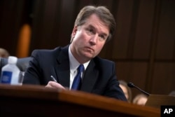 President Donald Trump's Supreme Court nominee, Brett Kavanaugh, takes notes as the Senate Judiciary Committee members make opening statements during his confirmation hearing, on Capitol Hill in Washington, Sept. 4, 2018.