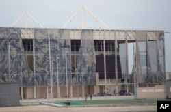 This Feb. 4, 2017, photo shows translucent tapestries created by Brazilian artist Adriana Varejao, falling from the exterior of Olympic Aquatic stadium inside Olympic Park in Rio de Janeiro, Brazil. The Olympic Park is now a cutting-edge ghost town.