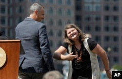 Jane Richard, right, sister of Boston Marathon bombing victim Martin Richard, bows toward the audience after making remarks as her father Bill Richard, left, looks on during groundbreaking ceremonies for a park named after Martin Richard, Aug. 16, 2017, in Boston.