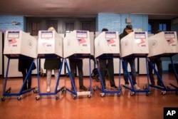 FILE - Voters fill out their forms at a polling station in the Brooklyn borough of New York, Nov. 8, 2016.