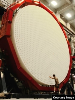 An observer with the Giant Magellan Telescope’s third primary mirror. (Ray Bertram/University of Arizona)