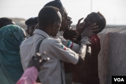 Police clash with families who don't want a mass grave containing their relatives to be exhumed in Berbera, Somaliland. (J. Patinkin/VOA)