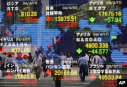 A securities firm's electronic stock indicator reflects pedestrians passing by in Tokyo, June 20, 2016. Global markets jumped Monday as polls suggest British voters on Thursday will choose to remain in the European Union.