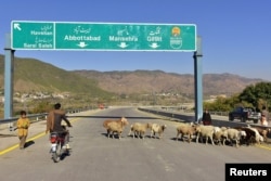 FILE - A Pakistani motorcyclist drives on a newly built Pakistan China Silk Road in Haripur, Pakistan, Dec. 22, 2017.