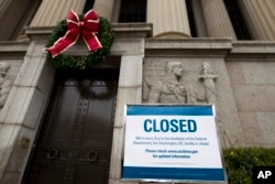 A closed sign is displayed at The National Archives entrance in Washington, Tuesday, Jan. 1, 2019, as a partial government shutdown appoaches its two-week mark.