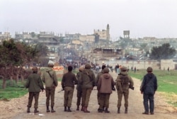 FILE - Israeli soldiers face Palestinian demonstrators, at Nuseirat refugee camp in the Gaza Strip, Dec. 14, 1987.
