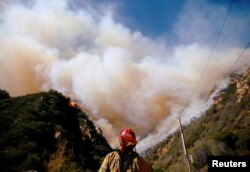 Firefighters battle the Woolsey Fire as it continues to burn in Malibu, California, Nov. 11, 2018.