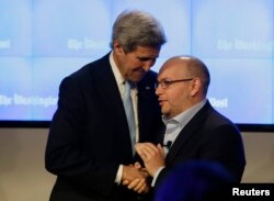 Washington Post reporter Jason Rezaian (R) is greeted by U.S. Secretary of State John Kerry at the grand opening of the Washington Post newsroom in Washington, Jan. 28, 2016.